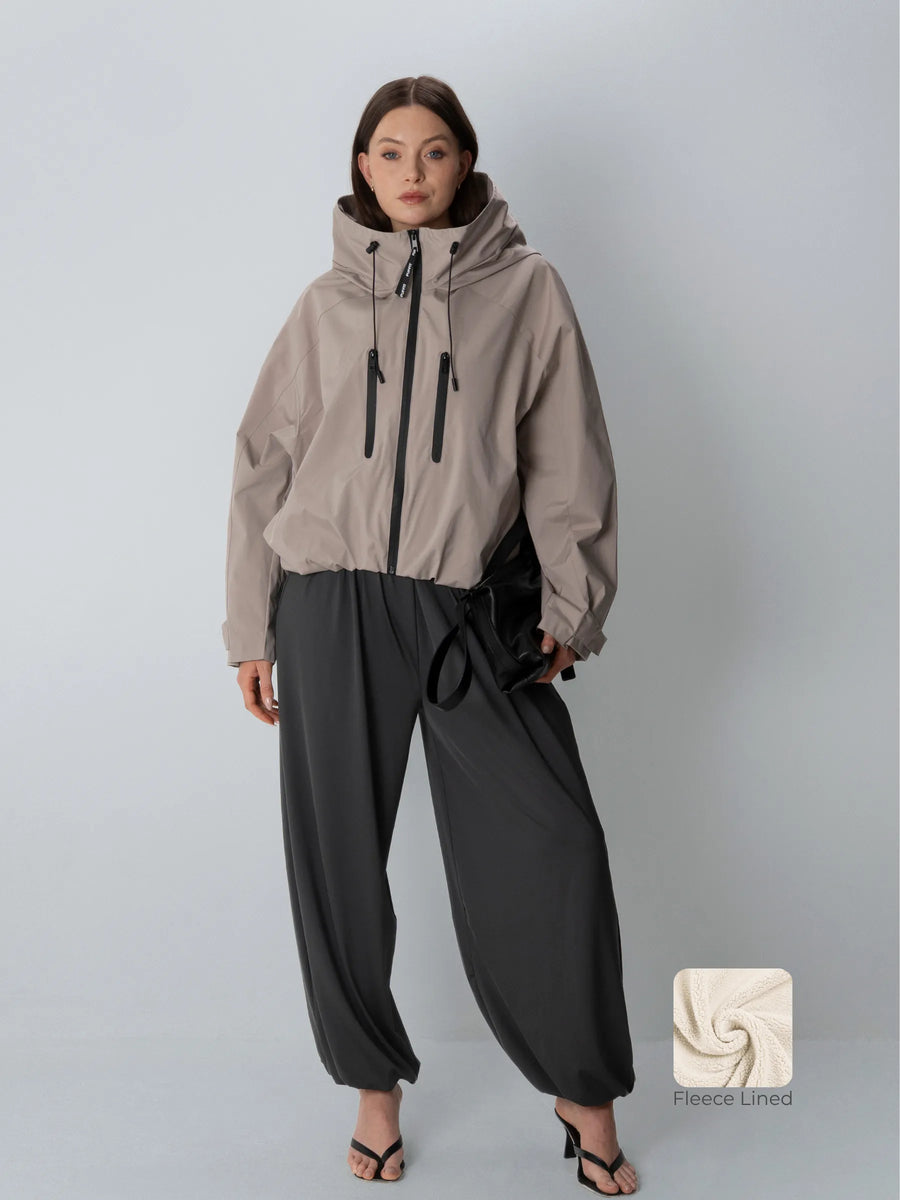 Model wearing PUFFIT Modern Taupe oversized waterproof rain jacket